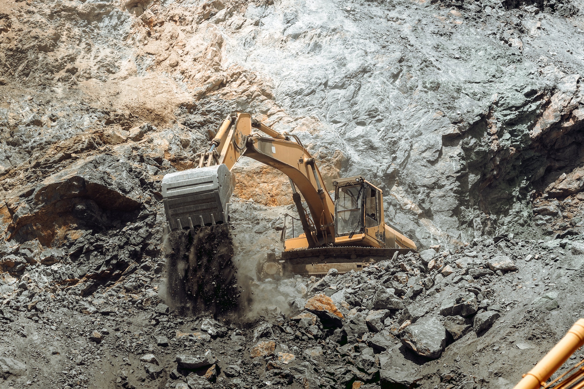 Industrial track type excavator working on highway construction site.