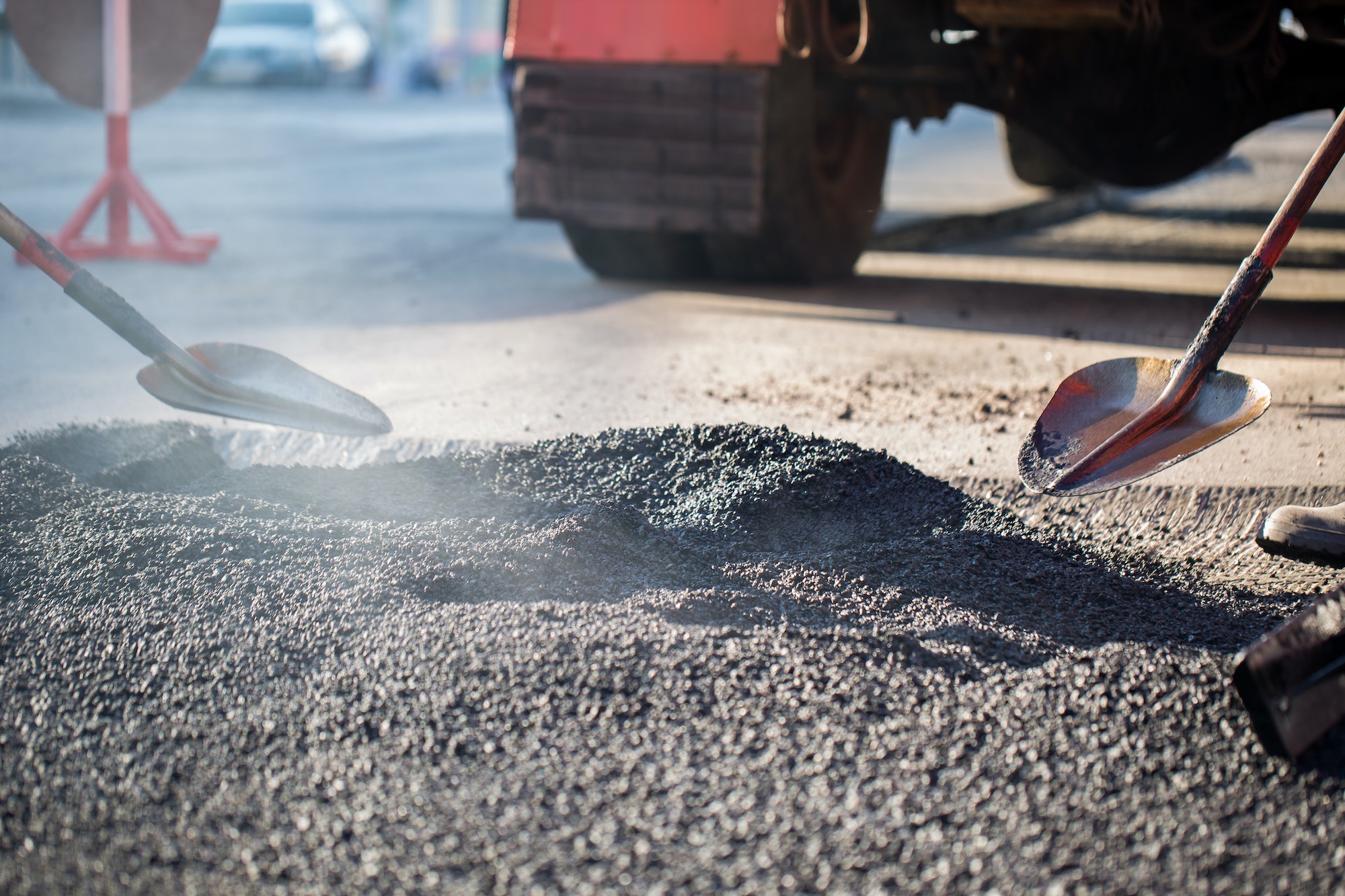 Young builder on Asphalting paver machine during Road street repairing works